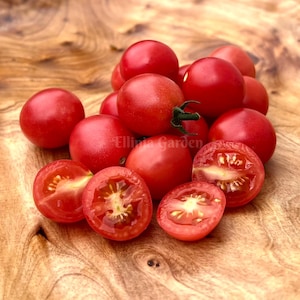 May include: A close-up of a pile of red cherry tomatoes on a wooden surface. Some of the tomatoes are cut in half, revealing their juicy insides.