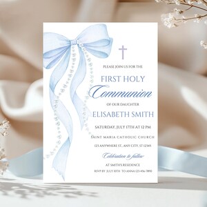 May include: A First Holy Communion invitation featuring a light blue watercolour bow and ribbons, with a string of pearls. The invitation includes the text: "First Holy Communion of our daughter Elisabeth Smith."