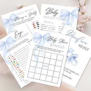 May include: A set of blue and white baby shower game cards with a watercolor bow design. The games include Guess Who, Emoji Pictionary, Baby Shower Bingo, and Pacifier Hunt.