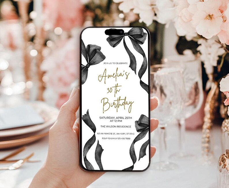 May include: A white and black birthday invitation with gold text. The invitation features a black ribbon with a bow and the text "Join us to celebrate Amelia's 30th Birthday". The invitation also includes the date, time, and location of the event.