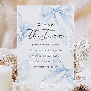 May include: A blue and white invitation card with a watercolor design of blue bows. The text on the card reads "Olivia is Thirteen. Please join us to celebrate Saturday, February 22th at 12 PM. The Wilson Residence 123 Anywhere St., Any City, ST 12345 RSVP to Emily 123-456-7890"