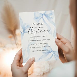May include: A blue and white invitation card with watercolor blue bows and the text "Olivia is thirteen" and details for a birthday party.
