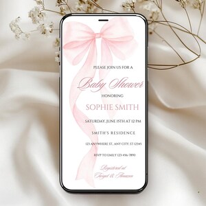 May include: A pink baby shower invitation with a watercolor bow on a white background. The invitation includes the text "Please join us for a Baby Shower honoring Sophie Smith, Saturday, June 15th at 12 PM, Smith's Residence, 123 Anywhere St. Any City, ST 12345, RSVP to Emily 123-456-7890, Registered at Target & Amazon."