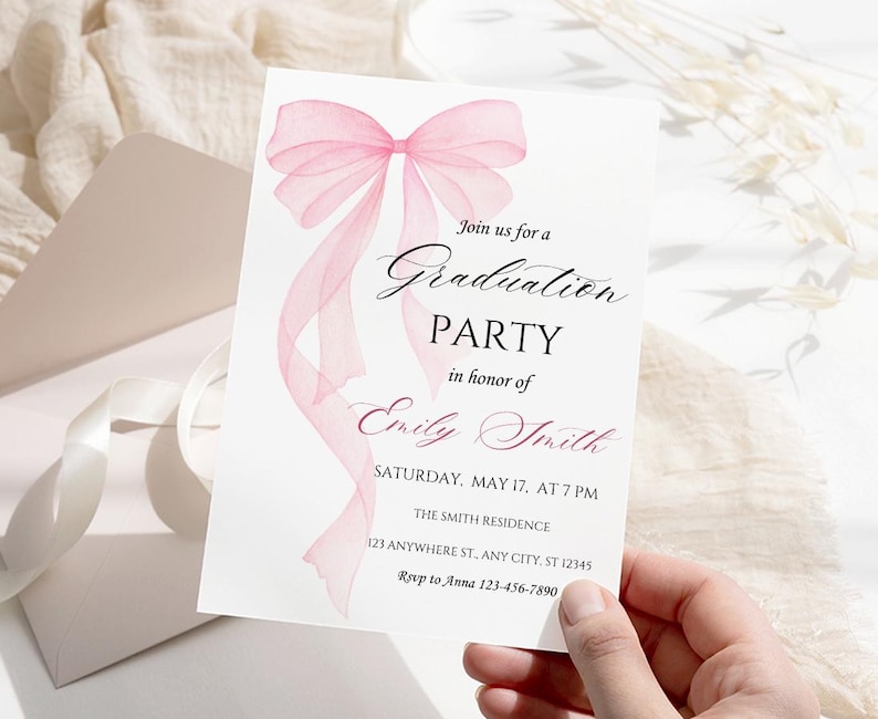 Op de afbeelding: Roze uitnodiging voor een afstudeerfeest met een aquarel strik en de tekst "Doe mee met ons voor een afstudeerfeest ter ere van Emily Smith. Zaterdag 17 mei om 19:00 uur. De Smith Residence, 123 Anywhere St, Any City, ST 12345. Rsvp naar Anna 123-456-7890"