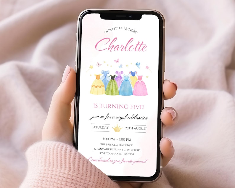 K&ouml;nnte beinhalten: Ein Smartphone zeigt eine Geburtstagseinladung. Der Text "Unsere kleine Prinzessin Charlotte wird f&uuml;nf!" ist zu sehen. Die Einladung zeigt Aquarellkleider in verschiedenen Farben. Die Veranstaltungsdetails sind enthalten.
