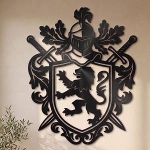 Puede incluir: Una pieza de arte mural de metal negro con un diseño de escudo de armas heráldico. El escudo central muestra un león rampante, flanqueado por dos espadas cruzadas. Sobre el escudo se sitúa un yelmo de caballero con adornos de hojas.