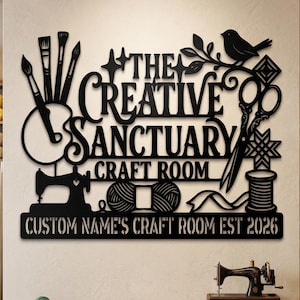 May include: A black metal wall sign featuring the text "THE CREATIVE SANCTUARY CRAFT ROOM" and "CUSTOM NAME'S CRAFT ROOM EST 2026". The design includes silhouettes of paintbrushes, a palette, a bird, scissors, a sewing machine, and yarn.