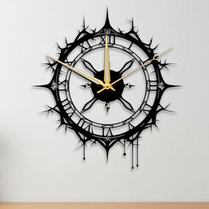 Puede incluir: Un reloj de pared decorativo negro con un diseño único. El reloj presenta números romanos y manecillas doradas. El borde exterior del reloj tiene un diseño puntiagudo en forma de estrella. El reloj está montado en una pared blanca.