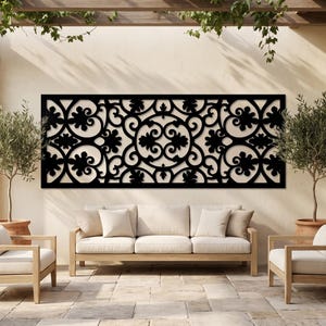 Könnte beinhalten: Ein großes, rechteckiges schwarzes Wandkunstobjekt mit einem komplexen, symmetrischen, lasergeschnittenen Muster aus geschwungenen Ranken, floralen Motiven und kreisförmigen Elementen. Das Design besteht aus sich wiederholenden organischen Formen und Kurven und bildet ein dekoratives, durchbrochenes Paneel, das flach an einer hellen Wandfläche montiert ist.