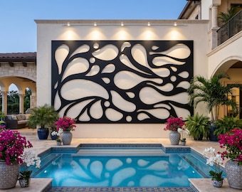 May include: A large rectangular black metal wall art panel with an abstract cutout pattern of fluid, organic shapes mounted on a beige exterior wall above a swimming pool, illuminated by a row of five small spotlights positioned along the top edge.