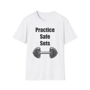 Könnte beinhalten: Weißes T-Shirt mit dem schwarzen Text "Practice Safe Sets" und einer schwarzen Hantel-Grafik. Das T-Shirt mit Rundhalsausschnitt eignet sich für Workouts oder Freizeitkleidung.