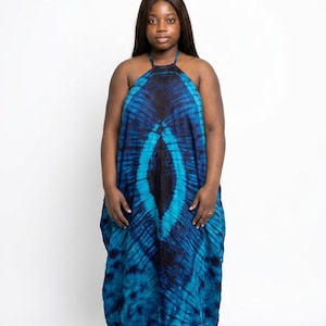 May include: A long, flowing halter dress in shades of blue and black. The dress features a tie-dye pattern with a central design element. The model is wearing the dress against a white background.