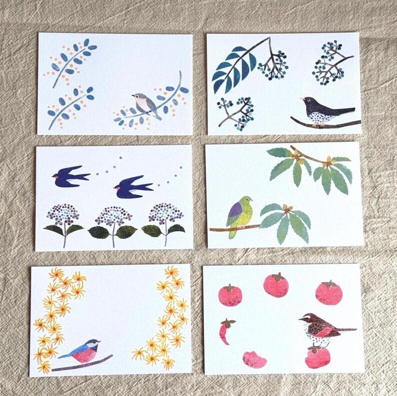 May include: Set of six white greeting cards with colorful illustrations of birds, flowers, and fruit. Each card features a unique design, including birds perched on branches, flying swallows, and floral arrangements. The cards are perfect for various occasions.