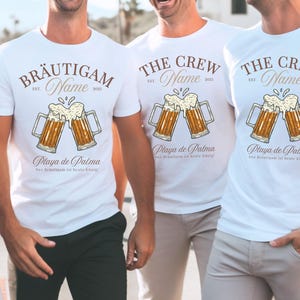 Puede incluir: Camisetas blancas con un dise&ntilde;o tem&aacute;tico de cerveza. El dise&ntilde;o incluye dos jarras de cerveza chocando, el texto "BRAUTIGAM" y "THE CREW", el nombre, el a&ntilde;o 2025 y "Playa de Palma". Tambi&eacute;n se incluye la frase alemana "Der Br&auml;utigam ist heute K&ouml;nig!".