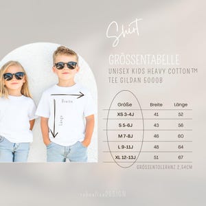 May include: Size chart for unisex kids' t-shirts made of heavy cotton. The chart shows sizes XS 3-4J, S 5-6J, M 7-8J, L 9-11J, and XL 12-13J with corresponding width and length measurements in inches. The chart also states that the size tolerance is 2.54 cm.