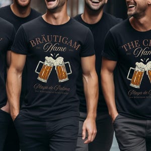 Puede incluir: Camisetas negras de cuello redondo con un gr&aacute;fico de jarra de cerveza. Las camisetas tienen texto que dice "THE CREW" y "BR&Auml;UTIGAM" con "Name" y "Playa de Palma" debajo de las jarras de cerveza. Tambi&eacute;n est&aacute; presente el texto "Der Br&auml;utigam ist heute K&ouml;nig!"
