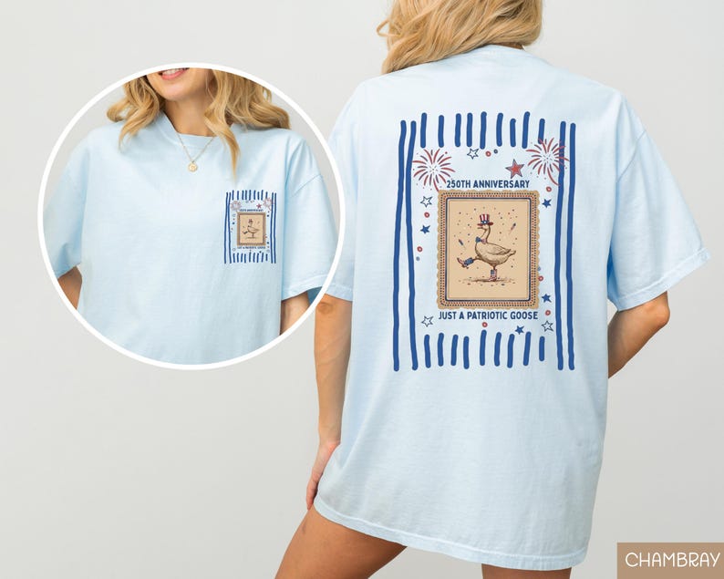 May include: Pale blue t-shirt featuring a patriotic goose design. The back displays a framed illustration of a goose in a top hat and holding a cane, with text reading "250th Anniversary" and "Just a Patriotic Goose."