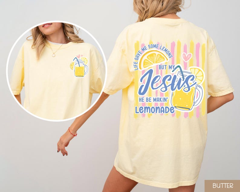 May include: Butter yellow t-shirt with a lemonade graphic on the front and back. The front features a lemonade jar illustration. The back has the text "Life gave me some lemons but my Jesus he be makin' lemonade."