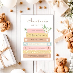 Op de afbeelding: Een roze en gele uitnodigingskaart met een stapel boeken versierd met bloemen. De tekst op de kaart luidt "Amelia's 1st Chapter" en "Amelia's 1st Birthday". De uitnodiging bevat de datum, tijd, adres en RSVP-informatie.