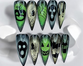 May include: A set of ten long, pointed fingernails with Halloween-themed designs. The nails feature a variety of images, including jack-o'-lanterns, spiders, spiderwebs, skulls, and bats, in shades of green, black, and gold.