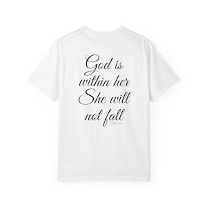Op de afbeelding: Wit T-shirt met de tekst "God is within her, She will not fall" in zwart script. De tekst staat gecentreerd op de achterkant van het shirt, met de verwijzing "Psalm 46:5" eronder.