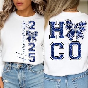 Könnte beinhalten: Weißes Sweatshirt mit "Homecoming 25" in blauem Glitzer-Schriftzug und einer Schleifengrafik. Auf der Rückseite des Sweatshirts stehen "HC" und "CO" in blauem Glitzer mit einer Schleifengrafik. Lässiger Stil.