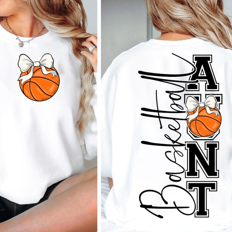 Op de afbeelding: Witte sweatshirt met een basketbalafbeelding en een witte strik. De achterkant van de sweatshirt heeft het woord "Basketball" in een verticaal script, samen met het woord "ANT" en een andere basketbalafbeelding.