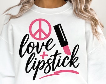 Könnte beinhalten: Weißes Sweatshirt mit den Worten "love + lipstick" in schwarzer Schrift. Das Design umfasst ein rosa Friedenszeichen und einen rosa Lippenstift. Dies ist ein lässiges Kleidungsstück für den Alltag.