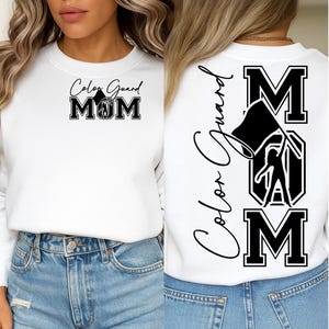 May include: White sweatshirt with "Color Guard MOM" printed on the front and back. The front design features the text in a combination of script and bold block letters, with a flag and a marching band member graphic. The back design repeats the text and graphic.