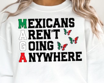 May include: White sweatshirt with the text "MEXICANS AREN'T GOING ANYWHERE" in black letters. The letters are stacked vertically and each letter is a different color: green, white, red, and green. There are three butterflies with the colors of the Mexican flag.