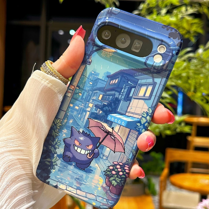 May include: A blue phone case featuring a cartoon illustration of a purple creature holding a pink umbrella in a rainy street scene. The case has a glossy finish and a detailed cityscape design.