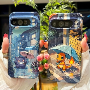 Puede incluir: Dos fundas para teléfono con ilustraciones pixeladas. Una funda presenta un Gengar morado con un paraguas en una escena callejera lluviosa. La otra funda muestra un Charmander con un paraguas en un entorno similar. Ambas fundas tienen un esquema de color azul y blanco.
