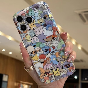 May include: A colorful phone case featuring a repeating pattern of various cartoon characters in a variety of colors. The case has cutouts for the phone's camera lenses and flash. The case is held in a hand.