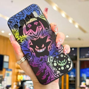 Puede incluir: Funda de tel&eacute;fono negra con un dise&ntilde;o colorido de personajes de dibujos animados en tonos morados, azules, amarillos y verdes. La funda tiene un acabado brillante y se sostiene en una mano.