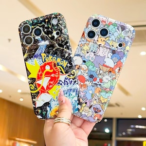 May include: Two phone cases with colorful designs. One case features a red and yellow cartoon character with the word "Pokemon" on a black background. The other case is covered in various cartoon characters in different colors.