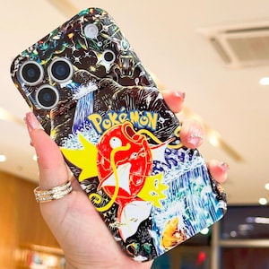 May include: A colorful phone case featuring a vibrant illustration of a red and yellow Pokemon character with the word "Pokemon" in yellow. The case has a black background with a waterfall design and a multi-camera lens.