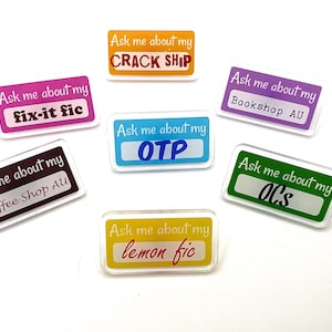 May include: A collection of seven rectangular acrylic pins featuring the text Ask me about my followed by specific phrases including CRACK SHIP, fix-it fic, Bookshop AU, OTP, Coffee Shop AU, OCs, and lemon fic in various colors like orange, pink, purple, blue, brown, green, and yellow.