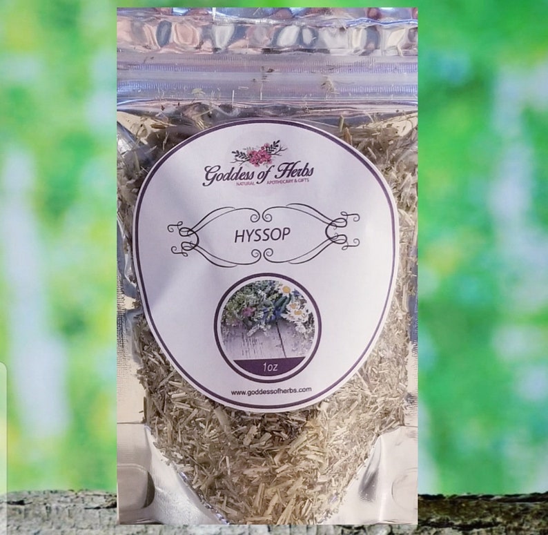 May include: A clear plastic bag filled with dried Hyssop herb. The bag has a white label with the text "Goddess of Herbs" and "Hyssop" in a pink font. The label also includes the text "1 oz" and a website address.