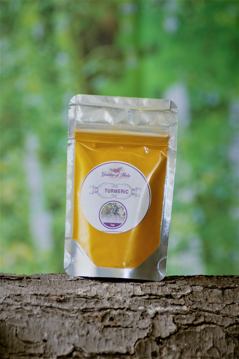 Pode incluir: Um saco de fecho herm&eacute;tico prateado cheio de p&oacute; de a&ccedil;afr&atilde;o amarelo. O saco tem um r&oacute;tulo branco com o texto "Goddess of Herbs" e "TURMERIC" em texto roxo. O r&oacute;tulo tamb&eacute;m inclui uma pequena imagem de uma planta e o texto "1oz".
