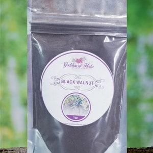 May include: A small resealable bag containing black walnut powder. The bag has a white label with the text "Goddess of Herbs" and "BLACK WALNUT" in a purple circle. The label also includes the text "1 oz" and a website address.