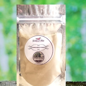 Op de afbeelding: Een klein, hersluitbaar zakje met beige poeder, gelabeld "Goddess of Herbs Ashwagandha Powder 1 oz www.goddessofherbs.com"