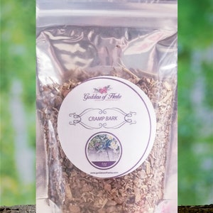 May include: A clear plastic bag filled with brown, dried herbs. A white circular label features the text "Cramp Bark" and a floral illustration. The bag is labeled "1oz" and the brand name "Goddess of Herbs" is visible.