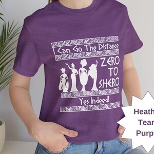 May include: Purple t-shirt with a white graphic of four women in silhouette with the text "I Can Go The Distance Zero To Shero Yes Indeed!"