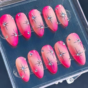 Chrome pink aura airbrush with silver starburst and rhinestone accents medium almond press on nails