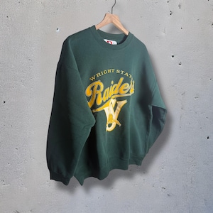 May include: A dark green sweatshirt with the text "WRIGHT STATE Raiders" in yellow and white. The sweatshirt is hanging on a wooden hanger against a grey background. The Raiders logo includes a stylized "W".