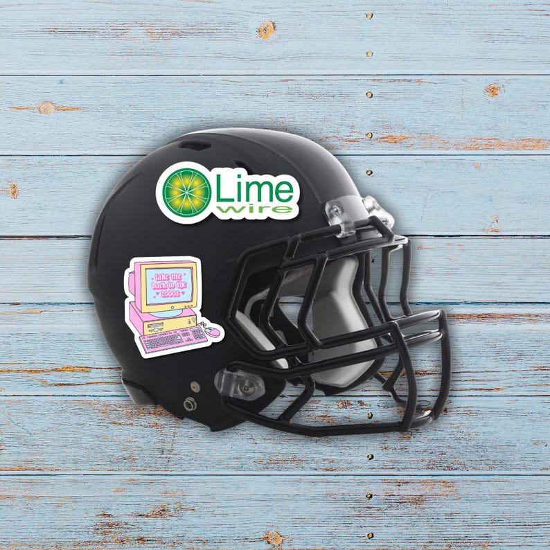 Puede incluir: Casco de f&uacute;tbol americano negro con pegatinas. Una pegatina tiene el texto "Lime Wire" y un gr&aacute;fico de lima. Otra pegatina presenta un ordenador rosa con el texto "Save the internet, download the boogs".