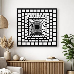 Peut inclure: Une œuvre d'art murale géométrique en noir et blanc représentant un motif carré avec des carrés concentriques créant un effet de tunnel. L'œuvre est encadrée et montée sur un mur blanc, ajoutant une touche moderne à la décoration de la pièce.