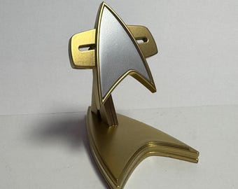 スタートレック ヴォイジャー/DS9をイメージした樹脂製プロップレプリカコムバッジ（ディスプレイスタンド付き）。