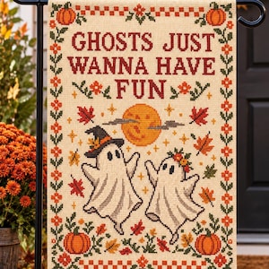 Peut inclure: Un drapeau de jardin rectangulaire avec un motif au point de croix sur fond cr&egrave;me. Le texte indique GHOSTS JUST WANNA HAVE FUN. Deux fant&ocirc;mes blancs sont repr&eacute;sent&eacute;s avec une lune jaune, des citrouilles orange et des feuilles d'automne.