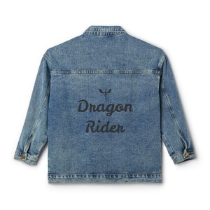 May include: A blue denim jacket with a black embroidered design on the back that says "Dragon Rider" with a dragon symbol above the text.